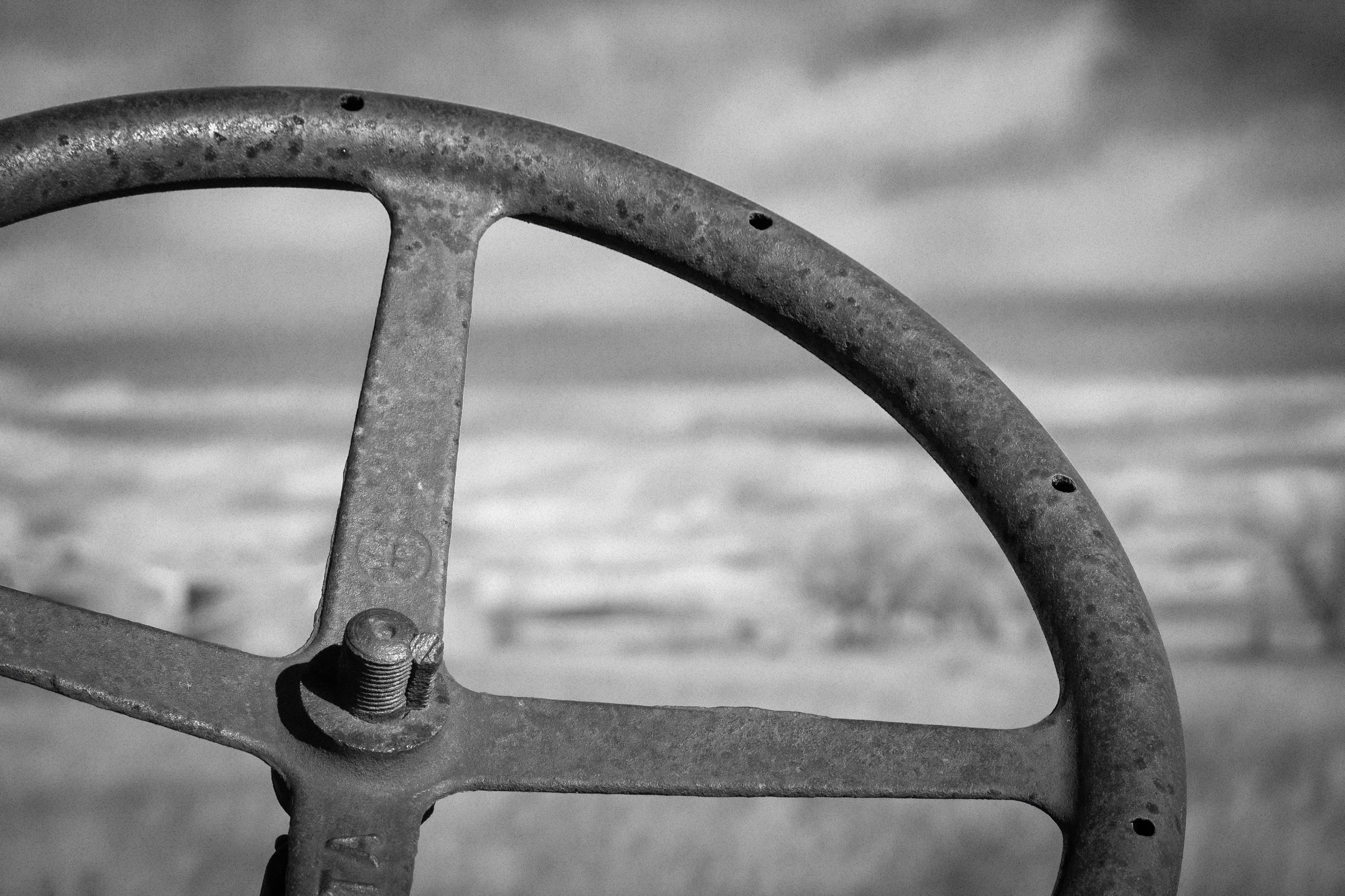 The old metal steering wheel of a turn of the century McCormick tractor.
